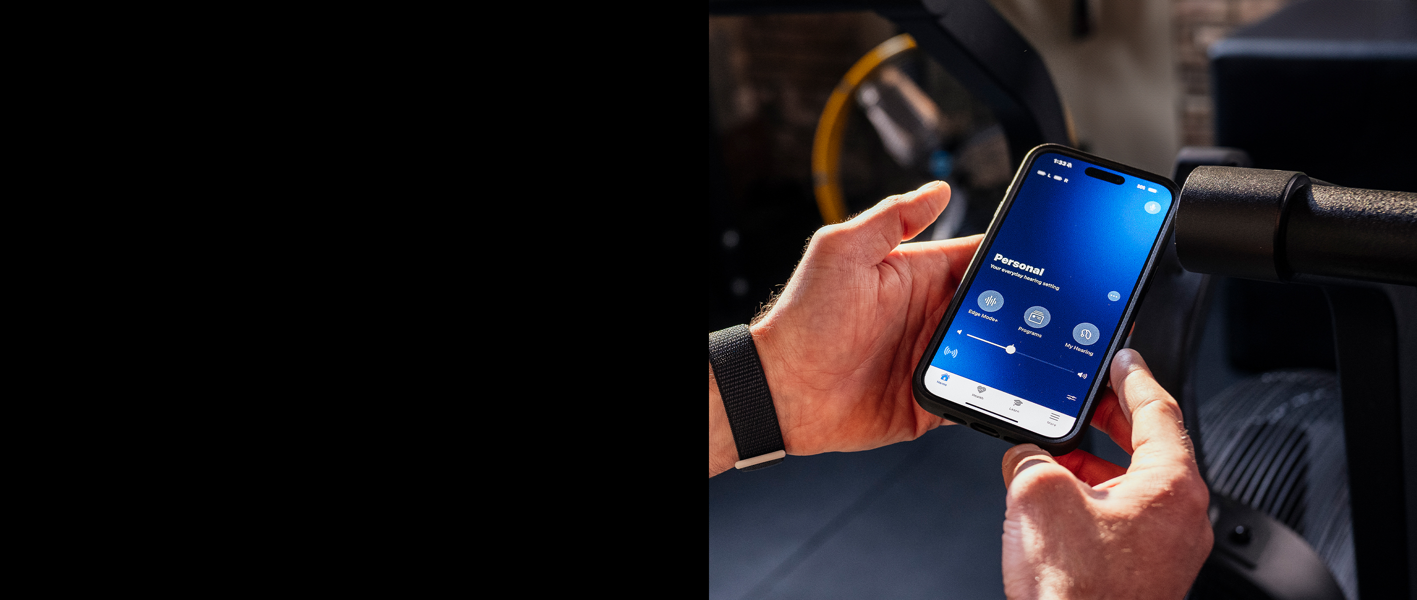 Hands holding a cell phone with the My Starkey app on screen.