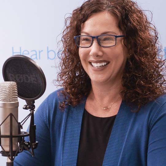 Smiling woman talking in a microphone